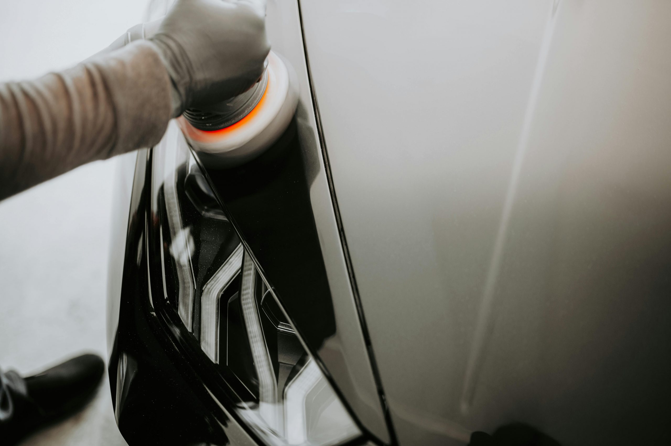 car buffer in use on the surface of a black car